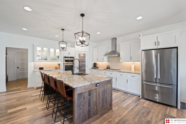 21034 X St, Omaha, NE 68022 - kitchen featuring stainless steel appliances, wall chimney range hood, backsplash, a breakfast bar area, and white cabinetry