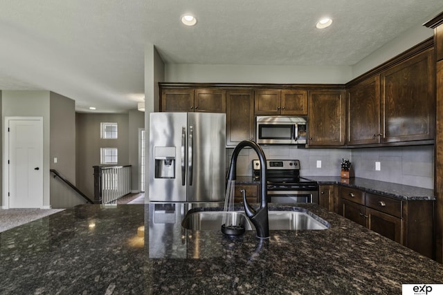 6015 S 193rd St, Omaha, NE 68135 - kitchen featuring stainless steel appliances, dark brown cabinetry, tasteful backsplash, recessed lighting, and dark stone counters