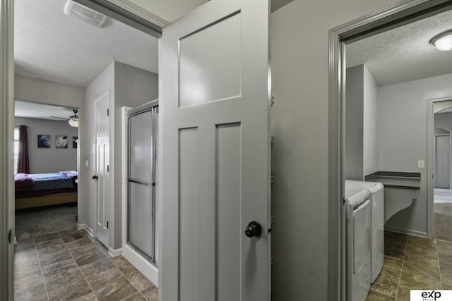 6015 S 193rd St, Omaha, NE 68135 - hallway featuring washer and clothes dryer, a textured ceiling, and stone finish floors