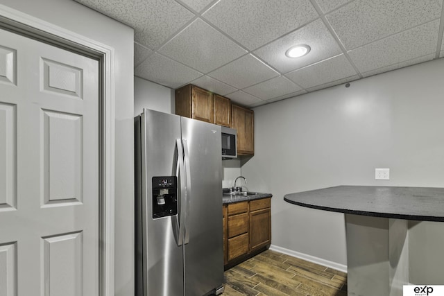 6015 S 193rd St, Omaha, NE 68135 - kitchen with appliances with stainless steel finishes, dark countertops, brown cabinets, and a paneled ceiling