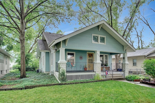 6409 Logan Ave, Lincoln, NE 68507 - bungalow-style house featuring covered porch, a front lawn, and roof with shingles