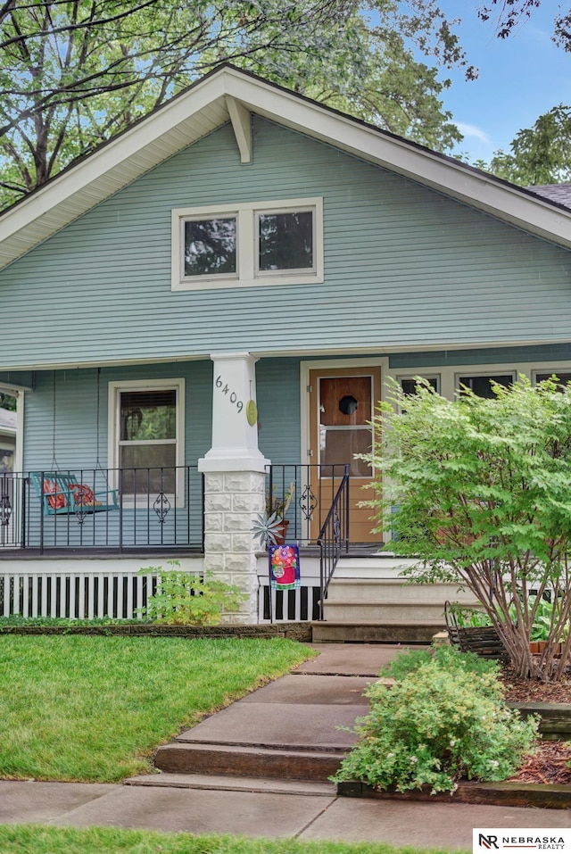 6409 Logan Ave, Lincoln, NE 68507 - view of front of house with covered porch and a front lawn