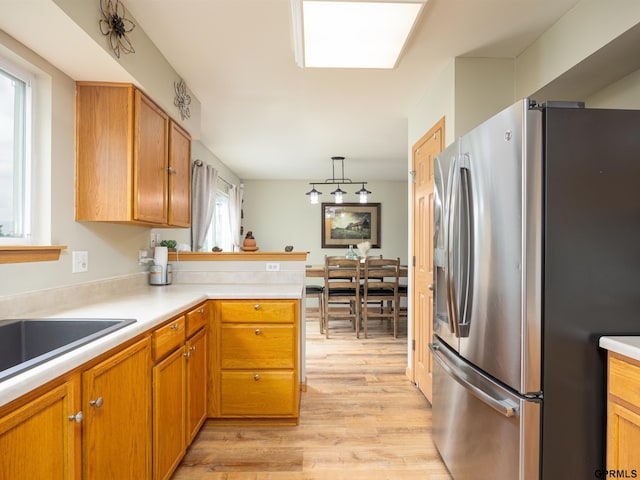 15413 Bondesson St, Bennington, NE 68007 - kitchen featuring stainless steel refrigerator with ice dispenser, light wood-style floors, light countertops, a peninsula, and brown cabinets