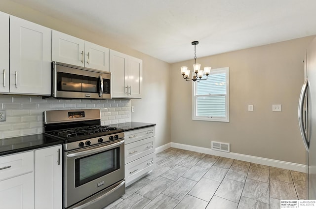 3207 S 121st St, Omaha, NE 68144 - kitchen with appliances with stainless steel finishes, a chandelier, dark countertops, and decorative backsplash