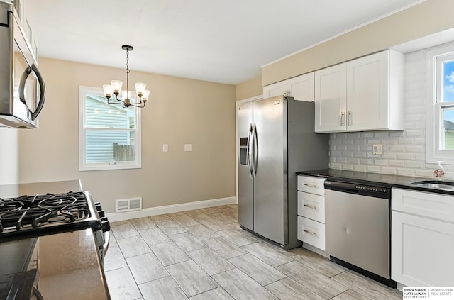 3207 S 121st St, Omaha, NE 68144 - kitchen with stainless steel appliances, dark countertops, healthy amount of natural light, and a chandelier