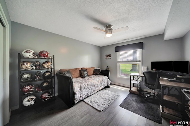 4000 S 56th St Unit 130C, Lincoln, NE 68516 - bedroom with a textured ceiling, wood finished floors, a desk, and a ceiling fan