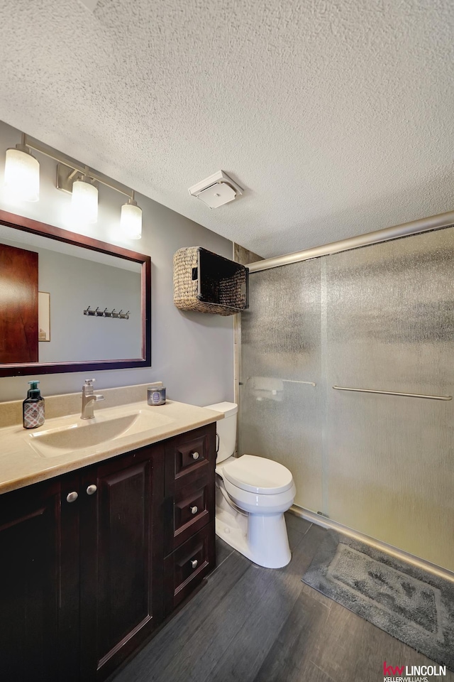 4000 S 56th St Unit 130C, Lincoln, NE 68516 - bathroom featuring vanity, wood finished floors, a stall shower, and a textured ceiling