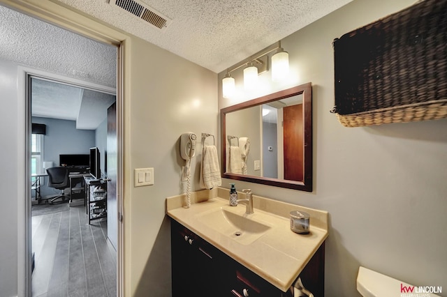4000 S 56th St Unit 130C, Lincoln, NE 68516 - half bathroom featuring a textured ceiling, vanity, and wood finished floors