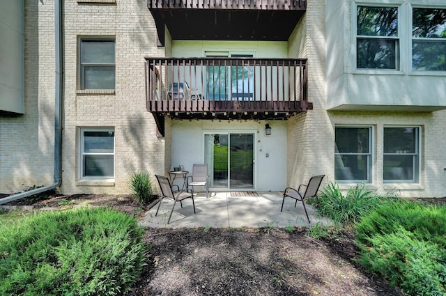 4000 S 56th St Unit 130C, Lincoln, NE 68516 - rear view of property featuring a balcony, a patio area, brick siding, and stucco siding