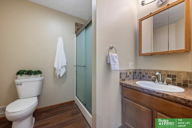 754 10th St, Syracuse, NE 68446 - bathroom featuring wood finished floors, vanity, a shower stall, backsplash, and a textured ceiling
