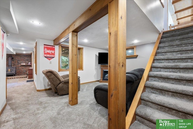 754 10th St, Syracuse, NE 68446 - carpeted living area with stairway, a wood stove, a fireplace, and recessed lighting
