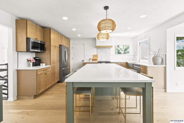 12328 Rose Ln, Omaha, NE 68154 - kitchen with stainless steel appliances, recessed lighting, backsplash, light wood-type flooring, and light countertops
