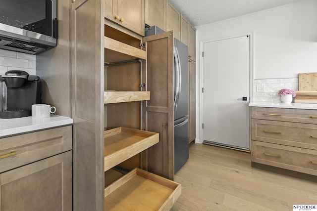 12328 Rose Ln, Omaha, NE 68154 - kitchen featuring stainless steel microwave, decorative backsplash, and light wood-style flooring