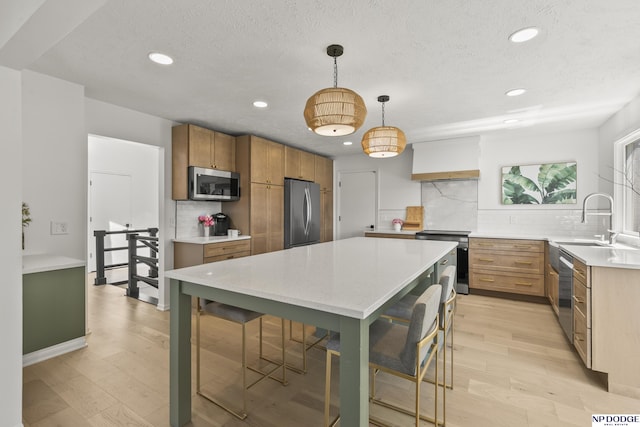 12328 Rose Ln, Omaha, NE 68154 - kitchen featuring appliances with stainless steel finishes, backsplash, recessed lighting, light wood-style flooring, and pendant lighting