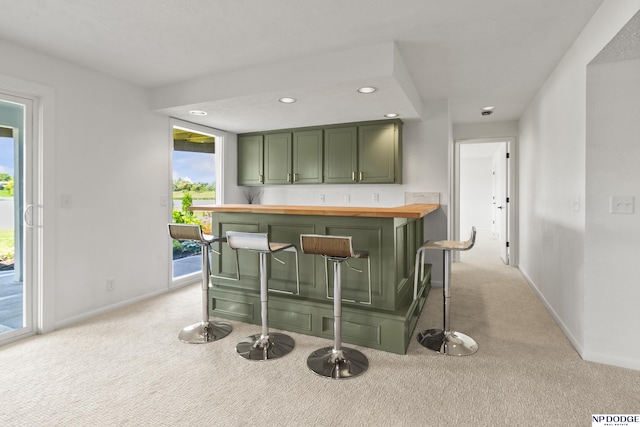 12328 Rose Ln, Omaha, NE 68154 - kitchen featuring green cabinetry, wood counters, light carpet, and recessed lighting