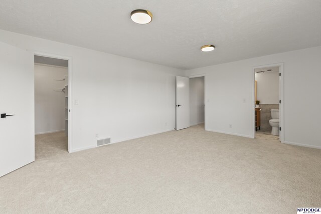 12328 Rose Ln, Omaha, NE 68154 - unfurnished bedroom featuring light carpet, a walk in closet, and connected bathroom