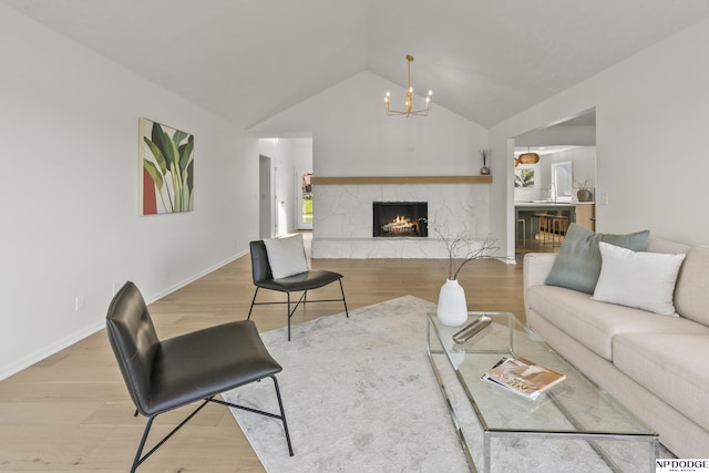 12328 Rose Ln, Omaha, NE 68154 - living area featuring a chandelier, wood finished floors, vaulted ceiling, and a stone fireplace