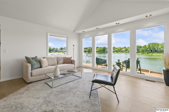 12328 Rose Ln, Omaha, NE 68154 - living area with vaulted ceiling, wood finished floors, a water view, and recessed lighting