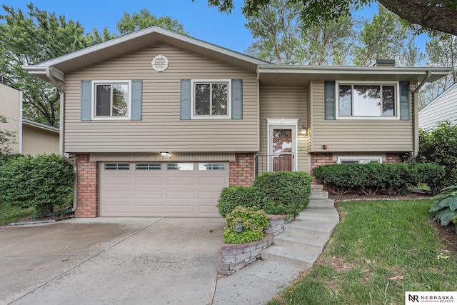 2219 Independence Dr, Lincoln, NE 68521 - bi-level home featuring an attached garage, concrete driveway, and brick siding