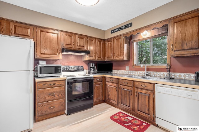 2219 Independence Dr, Lincoln, NE 68521 - kitchen with white appliances, under cabinet range hood, and brown cabinets