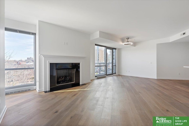 200 S 31st Ave Unit 4209, Omaha, NE 68131 - unfurnished living room featuring wood finished floors and a fireplace with flush hearth
