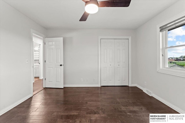 301 Gladys Ave, Yutan, NE 68073 - unfurnished bedroom with multiple windows, dark wood-style floors, and a closet