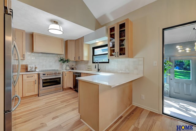 6833 Summerset Ct, Lincoln, NE 68516 - kitchen featuring appliances with stainless steel finishes, a peninsula, light wood-type flooring, light brown cabinets, and decorative backsplash