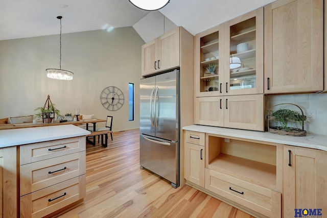6833 Summerset Ct, Lincoln, NE 68516 - kitchen featuring stainless steel refrigerator, light brown cabinets, vaulted ceiling, and light wood-type flooring