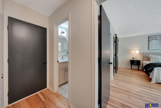 6833 Summerset Ct, Lincoln, NE 68516 - bedroom featuring light wood-style floors, a barn door, and ensuite bath
