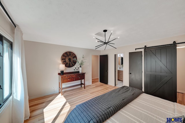 6833 Summerset Ct, Lincoln, NE 68516 - bedroom with a barn door, light wood finished floors, a chandelier, and ensuite bathroom