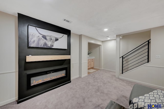 6833 Summerset Ct, Lincoln, NE 68516 - unfurnished living room featuring a glass covered fireplace, stairway, carpet flooring, recessed lighting, and wainscoting