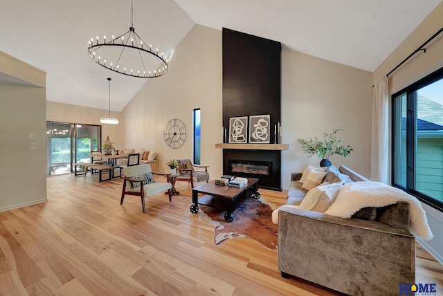 6833 Summerset Ct, Lincoln, NE 68516 - living room featuring high vaulted ceiling, healthy amount of natural light, a chandelier, and light wood-style floors