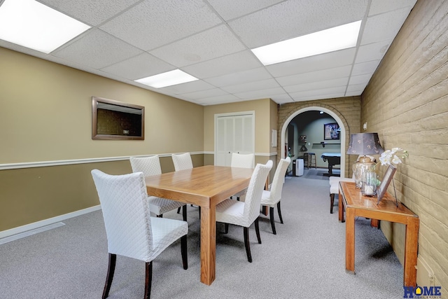 6833 Summerset Ct, Lincoln, NE 68516 - dining area featuring arched walkways, light colored carpet, a paneled ceiling, and wood walls