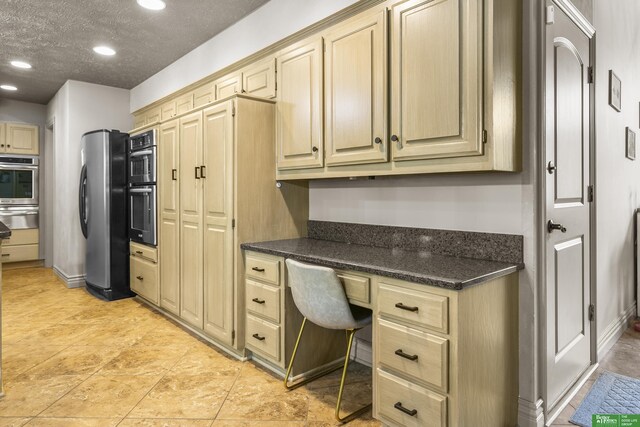 1015 N 127th Cir, Omaha, NE 68154 - kitchen featuring a warming drawer, appliances with stainless steel finishes, built in desk, recessed lighting, and a textured ceiling