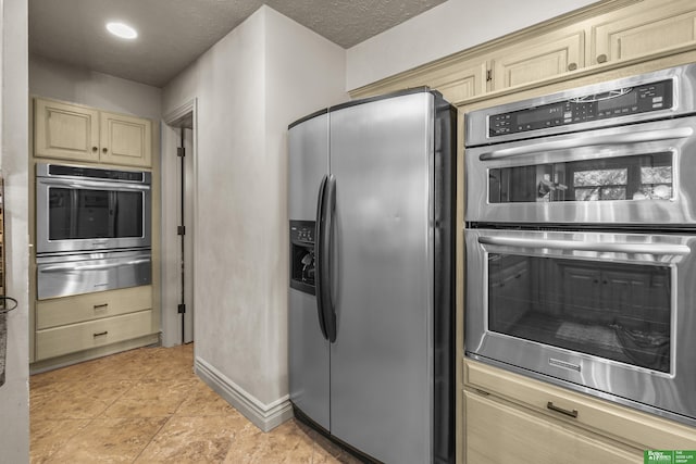 1015 N 127th Cir, Omaha, NE 68154 - kitchen featuring appliances with stainless steel finishes, a warming drawer, cream cabinetry, and a textured ceiling