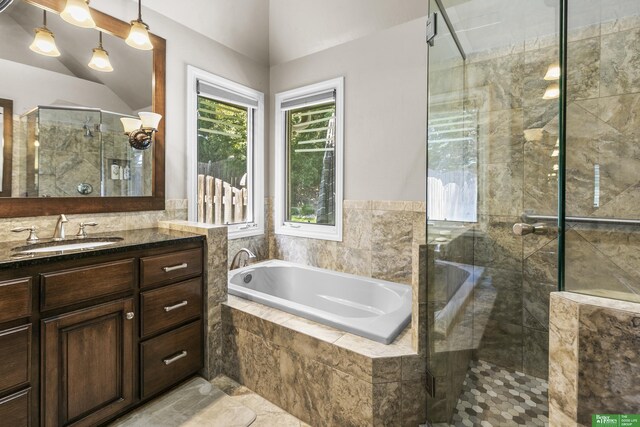 1015 N 127th Cir, Omaha, NE 68154 - bathroom with vanity, a garden tub, a stall shower, and vaulted ceiling
