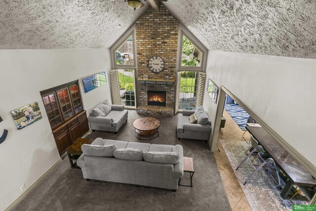 1015 N 127th Cir, Omaha, NE 68154 - living room featuring a brick fireplace, lofted ceiling, tile patterned floors, and a textured ceiling
