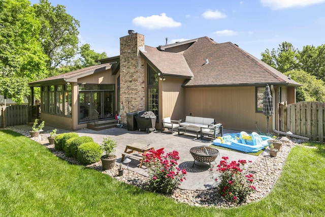 1015 N 127th Cir, Omaha, NE 68154 - rear view of property featuring an outdoor living space with a fire pit, a chimney, a patio area, a shingled roof, and a fenced backyard
