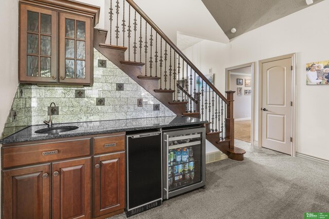 1015 N 127th Cir, Omaha, NE 68154 - indoor wet bar featuring wine cooler, lofted ceiling, decorative backsplash, stairs, and light carpet