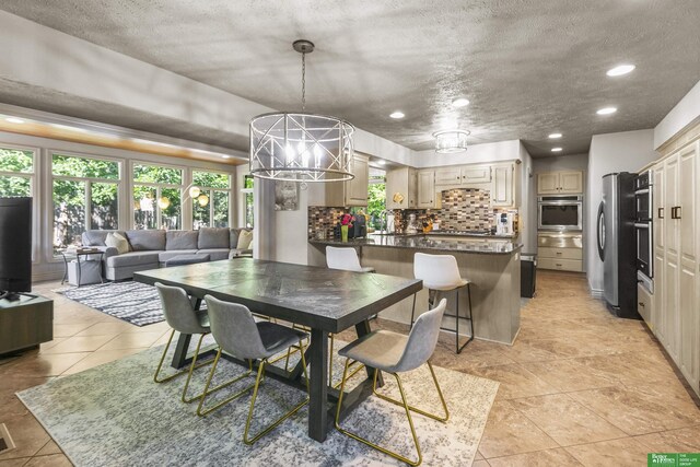 1015 N 127th Cir, Omaha, NE 68154 - dining room with light tile patterned flooring, recessed lighting, a chandelier, and a textured ceiling