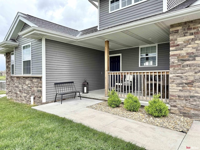 120 Snow Valley Cir, Palmyra, NE 68418 - entrance to property featuring a porch, roof with shingles, stone siding, and a yard