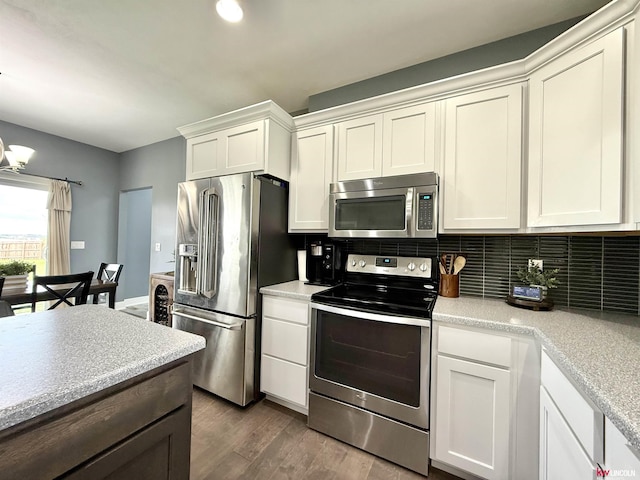 120 Snow Valley Cir, Palmyra, NE 68418 - kitchen featuring appliances with stainless steel finishes, decorative backsplash, wood finished floors, light countertops, and white cabinetry