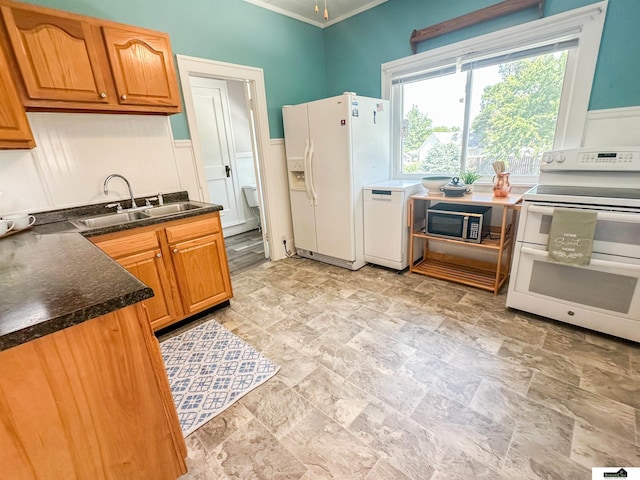 624 A St, Lincoln, NE 68502 - kitchen featuring white appliances, dark countertops, light stone finish floors, ornamental molding, and brown cabinets