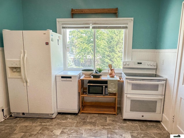 624 A St, Lincoln, NE 68502 - kitchen featuring white appliances, stone finish floors, plenty of natural light, and wainscoting