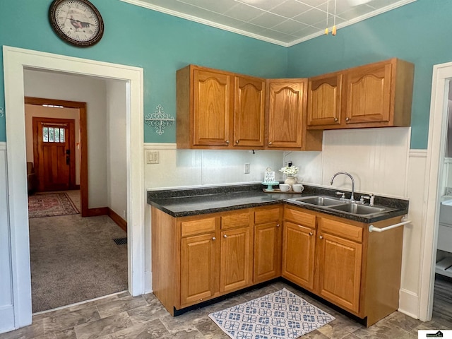 624 A St, Lincoln, NE 68502 - kitchen featuring dark countertops, brown cabinetry, carpet flooring, wainscoting, and ornamental molding