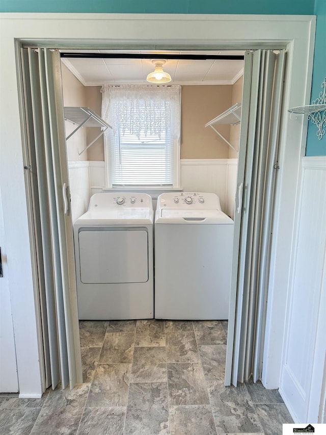 624 A St, Lincoln, NE 68502 - laundry area with ornamental molding, stone finish flooring, washer and dryer, and a wainscoted wall