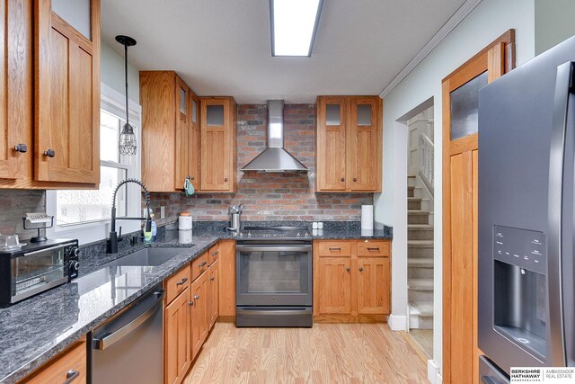 12310 Woolworth Ave, Omaha, NE 68144 - kitchen with appliances with stainless steel finishes, wall chimney exhaust hood, backsplash, light wood-style floors, and dark stone counters