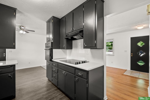 2330 S 90th St, Omaha, NE 68124 - kitchen with black appliances, under cabinet range hood, a ceiling fan, dark cabinetry, and a textured ceiling
