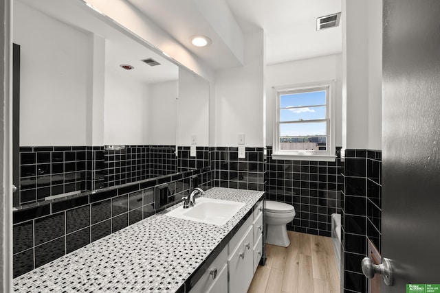 2330 S 90th St, Omaha, NE 68124 - bathroom featuring vanity, tile walls, a wainscoted wall, and wood finished floors