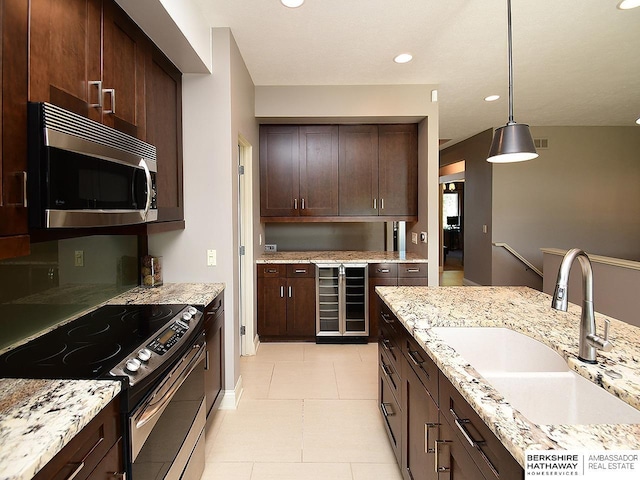 6535 N 157th St, Omaha, NE 68116 - kitchen featuring stainless steel appliances, beverage cooler, dark brown cabinetry, recessed lighting, and pendant lighting